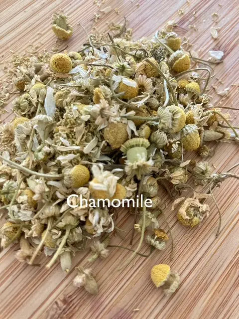 Dried chamomile flowers on a wooden surface